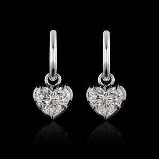 A pair of white gold huggie earrings with 1 carat each heart lab grown diamond drops in a georgian bezel-prong setting with black rhodium.