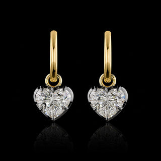 A pair of yellow gold huggie earrings with 1 carat each heart lab grown diamond drops in a georgian bezel-prong setting with black rhodium.