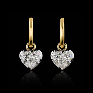 A pair of yellow gold huggie earrings with 1 carat each heart lab grown diamond drops in a white gold georgian bezel-prong setting.