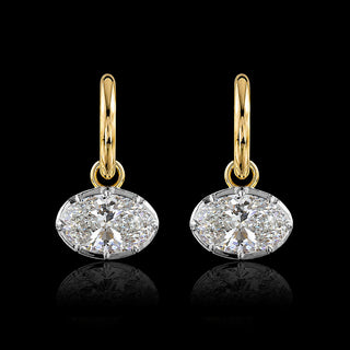 A pair of two tone gold huggie drop earrings with oval lab grown diamonds in a georgian setting with a white gold bezel-prong setting and yellow gold hoops.