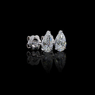 Angled side view of Pear-shaped lab grown diamond stud earrings in 14k white gold, claw prong setting, 2 carats total (1 carat each).