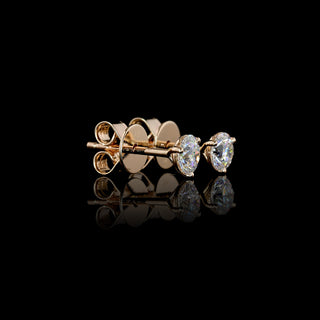 Side view of mini lab grown diamond round stud earrings with 0.5 carat total weight in rose gold, featuring a classic three-prong martini setting. || #metal_rose gold