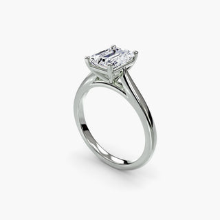 Cathedral solitaire engagement ring setting in white gold with an emerald-cut lab grown diamond, three-quarter view. || #metal_white gold|platinum #diamond shape_emerald