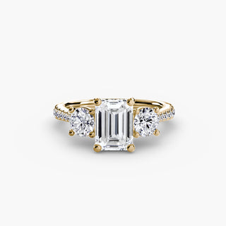 Three stone cathedral pave engagement ring setting with lab-grown diamonds in yellow gold, featuring emerald cut stones.