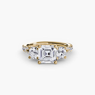 Three stone split shank pavé engagement ring setting with lab-grown diamonds and asscher cut center stone, yellow gold finish.