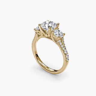 Three stone split shank pavé engagement ring setting with round diamonds in yellow gold, featuring detailed pave craftsmanship.