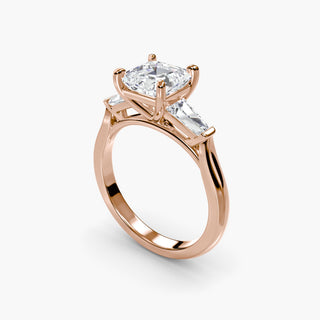 Three stone engagement ring setting in rose gold with an asscher-cut lab grown center diamond and tapered baguette side stones, three-quarter view. || #metal_rose gold #diamond shape_asscher