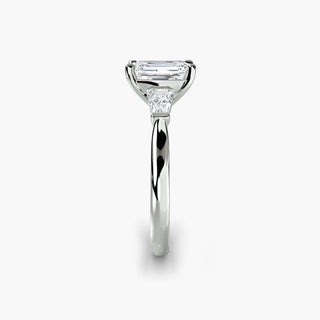 Three stone engagement ring setting in white gold showing the band profile, with an emerald-cut lab grown center diamond and tapered baguette side stones. || #metal_white gold|platinum #diamond shape_emerald