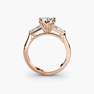 Three stone engagement ring setting in rose gold, side profile view with a heart-shaped lab grown center diamond and tapered baguette side stones. || #metal_rose gold #diamond shape_heart