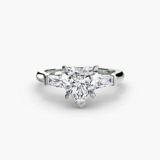 Three stone engagement ring setting in white gold, featuring a heart-shaped lab grown center diamond with tapered baguette side stones. || #metal_white gold|platinum #diamond shape_heart