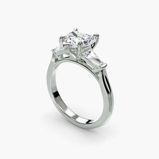 Three stone engagement ring setting in white gold with a heart-shaped lab grown center diamond and tapered baguette side stones, three-quarter view. || #metal_white gold|platinum #diamond shape_heart