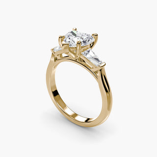 Three stone engagement ring setting in yellow gold with a heart-shaped lab grown center diamond and tapered baguette side stones, three-quarter view. || #metal_yellow gold #diamond shape_heart