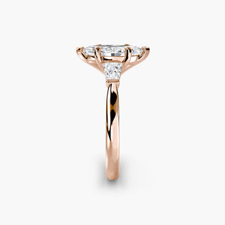 Three stone engagement ring setting in rose gold showing the band profile, with a marquise-cut lab grown center diamond and tapered baguette side stones. || #metal_rose gold #diamond shape_marquise