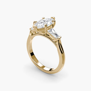 Three stone engagement ring setting in yellow gold with a marquise-cut lab grown center diamond and tapered baguette side stones, three-quarter view. || #metal_yellow gold #diamond shape_marquise