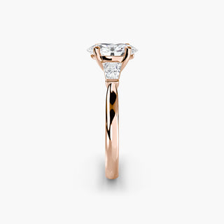 Three stone engagement ring setting in rose gold showing the band profile, with an oval-cut lab grown center diamond and tapered baguette side stones. || #metal_rose gold #diamond shape_oval