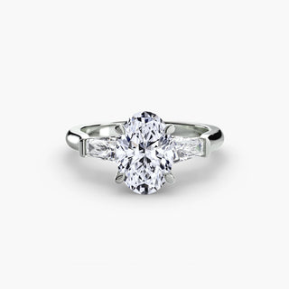 Three stone engagement ring setting in white gold, featuring an oval-cut lab grown center diamond with tapered baguette side stones. || #metal_white gold|platinum #diamond shape_oval