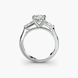 Three stone engagement ring setting in white gold, side profile view with an oval-cut lab grown center diamond and tapered baguette side stones. || #metal_white gold|platinum #diamond shape_oval