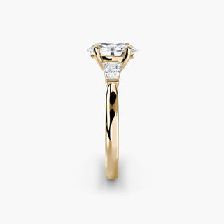 Three stone engagement ring setting in yellow gold showing the band profile, with an oval-cut lab grown center diamond and tapered baguette side stones. || #metal_yellow gold #diamond shape_oval