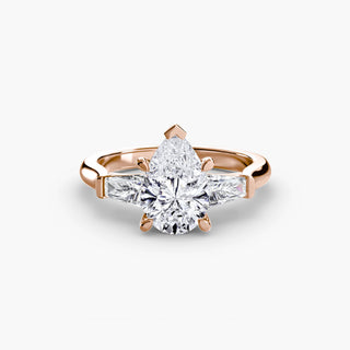 Three stone engagement ring setting in rose gold, featuring a pear-shaped lab grown center diamond with tapered baguette side stones. || #metal_rose gold #diamond shape_pear