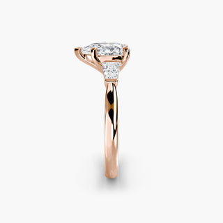 Three stone engagement ring setting in rose gold showing the band profile, with a pear-shaped lab grown center diamond and tapered baguette side stones. || #metal_rose gold #diamond shape_pear