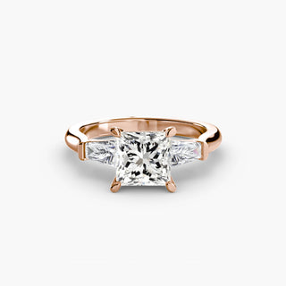 Three stone engagement ring setting in rose gold, featuring a princess-cut lab grown center diamond with tapered baguette side stones. || #metal_rose gold #diamond shape_princess