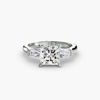 Three stone engagement ring setting in white gold, featuring a princess-cut lab grown center diamond with tapered baguette side stones. || #metal_white gold|platinum #diamond shape_princess