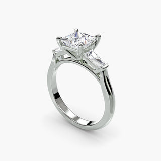 Three stone engagement ring setting in white gold with a princess-cut lab grown center diamond and tapered baguette side stones, three-quarter view. || #metal_white gold|platinum #diamond shape_princess