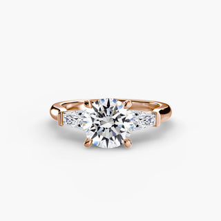 Three stone engagement ring setting in rose gold, featuring a round lab grown center diamond with tapered baguette side stones. || #metal_rose gold #diamond shape_round
