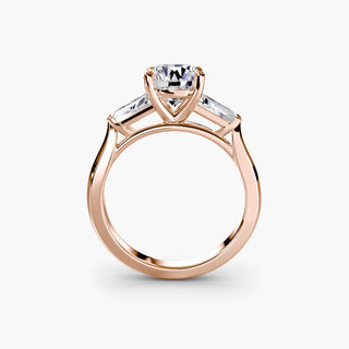 Three stone engagement ring setting in rose gold, side profile view with a round lab grown center diamond and tapered baguette side stones. || #metal_rose gold #diamond shape_round