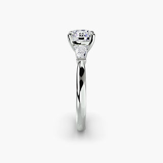 Three stone engagement ring setting in white gold showing the band profile, with a round lab grown center diamond and tapered baguette side stones. || #metal_white gold|platinum #diamond shape_round