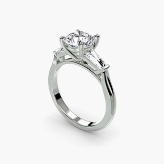 Three stone engagement ring setting in white gold with a round lab grown center diamond and tapered baguette side stones, three-quarter view. || #metal_white gold|platinum #diamond shape_round