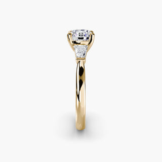 Three stone engagement ring setting in yellow gold showing the band profile, with a round lab grown center diamond and tapered baguette side stones. || #metal_yellow gold #diamond shape_round