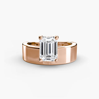 Solitaire engagement ring setting in rose gold, featuring an emerald-cut lab grown diamond slightly offset above a sculptural wide band. || #metal_rose gold