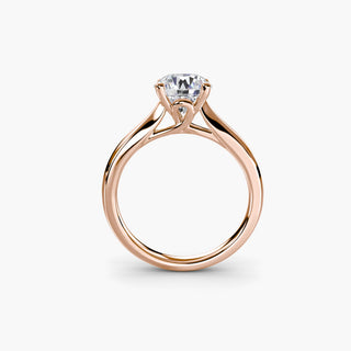 Solitaire engagement ring setting in rose gold, side profile view showing the cathedral shoulders and loop-style basket. || #metal_rose gold #diamond shape_round