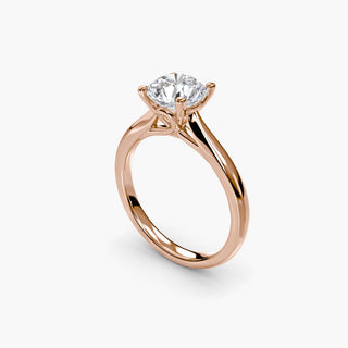 Solitaire engagement ring setting with a round lab grown diamond in rose gold, three-quarter view showing the loop basket. || #metal_rose gold #diamond shape_round