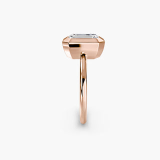 Bezel solitaire engagement ring setting in rose gold showing the band profile, with an emerald-cut lab grown diamond. || #metal_rose gold #diamond shape_emerald