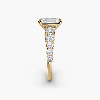 Gold graduation round U-prong diamond band engagement ring with emerald accents, showcasing detailed setting and side view.