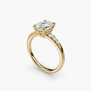 Pavé engagement ring setting in yellow gold with an oval-cut lab grown center diamond and graduated pavé accent diamonds, three-quarter view. || #metal_yellow gold #diamond shape_oval