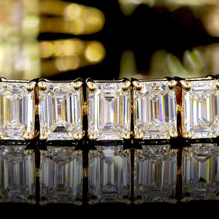 Yellow gold tennis bracelet with 10 carats of lab-grown emerald-cut diamonds, 7-inch length, showcasing sparkling gemstone details.