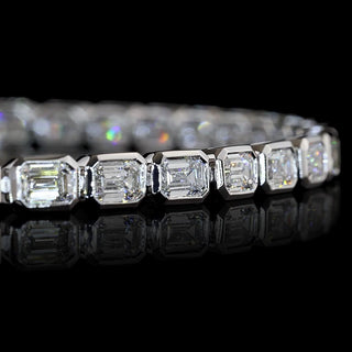 Close-up of East-West Emerald-cut lab grown diamond tennis bracelet in 14k white gold bezel setting.