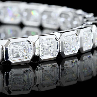 Lab-grown diamond tennis bracelet with emerald bezel accents, 7 carats total weight, in white gold, 7-inch length.