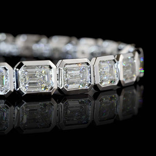Close-up of East-West Emerald-cut lab grown diamond tennis bracelet with 36-pointer diamonds in 14k white gold bezel setting, 10 carat total weight.