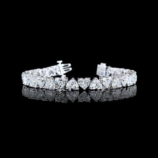 Alternating heart-shaped lab-grown diamond tennis bracelet with 25 carats total weight and 28 sparkling hearts in white gold.
