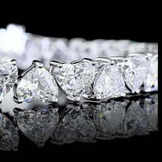 Alternating heart-shaped lab-grown diamond tennis bracelet with 25 carats total weight in white gold, featuring 28 diamonds.
