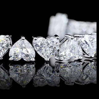 Alternating heart-shaped lab-grown diamond tennis bracelet with 25 carats total weight, white gold setting, 28 diamonds.