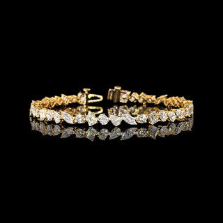 Yellow gold 7 ct tw lab-grown diamond tennis bracelet with mixed shape diamonds on a 7-inch chain.