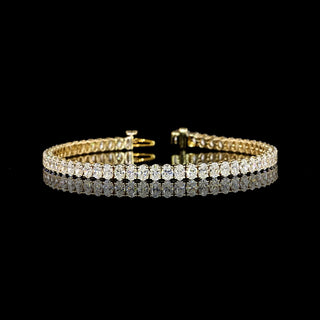 Oval lab-grown diamond tennis bracelet with 7 carats total weight on a 14k yellow gold chain, 7-inch length, elegant jewelry piece.