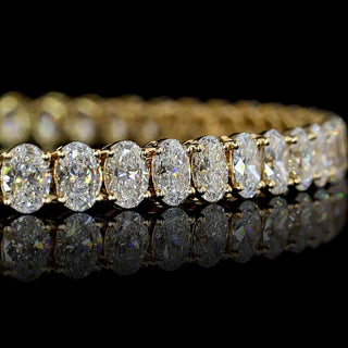 Oval lab-grown diamond tennis bracelet with 8 carats total weight, 56 oval diamonds, 7-inch yellow gold chain.