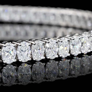 Oval lab-grown diamond tennis bracelet with 5 carats total weight in white gold, featuring 7-inch length and elegant design.
