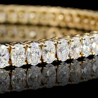 Yellow gold lab-grown diamond tennis bracelet with 5 carats total weight, oval cut diamonds, 7-inch length, stylish and elegant.